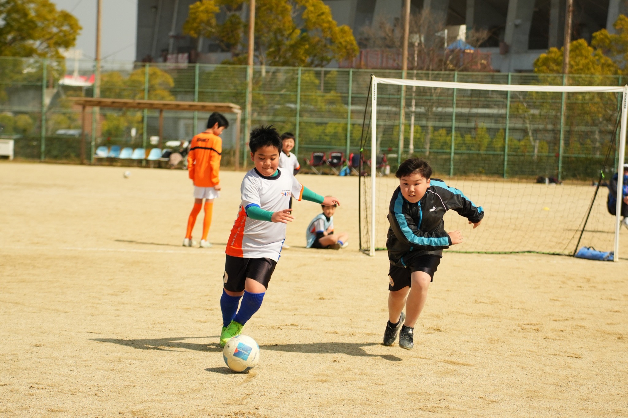 ボールを運びながら相手を抜こうとする選手