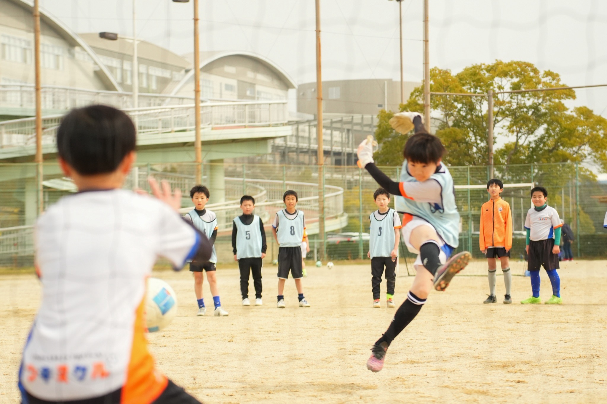 仲間が見守るなか力強くボールを蹴る選手
